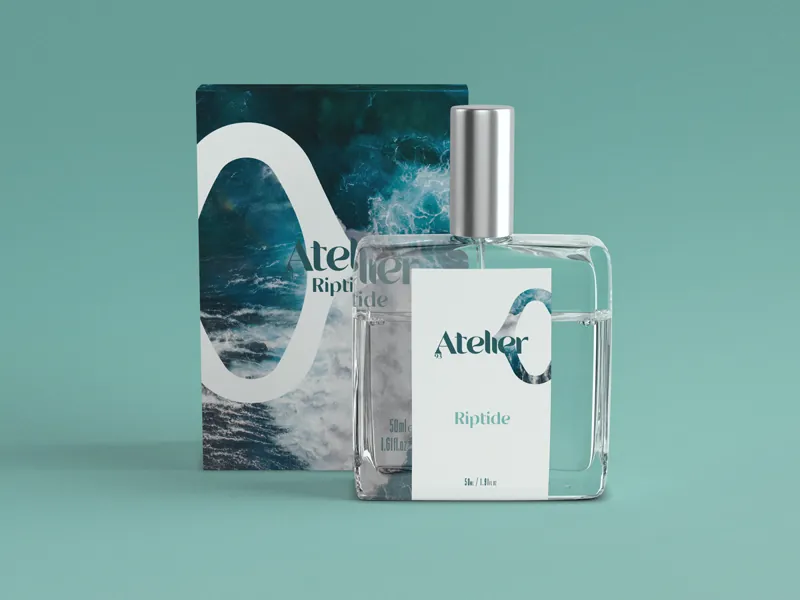 A clear perfume bottle labelled Atelier Riptide in front of its box, which wraps a photograph of a breaking wave around a large green O.